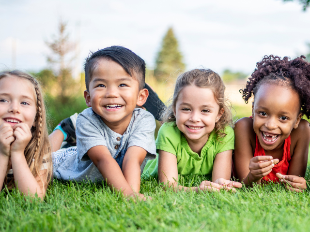 Kids laying down in grass