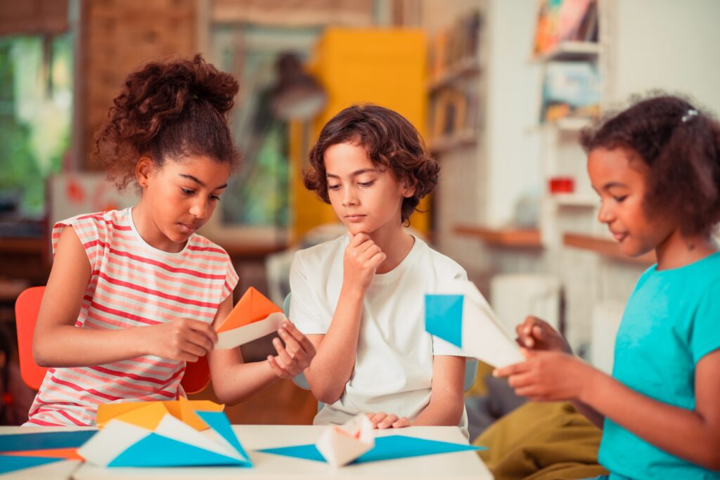 Gripping activity. A group of classmates learning to make origami