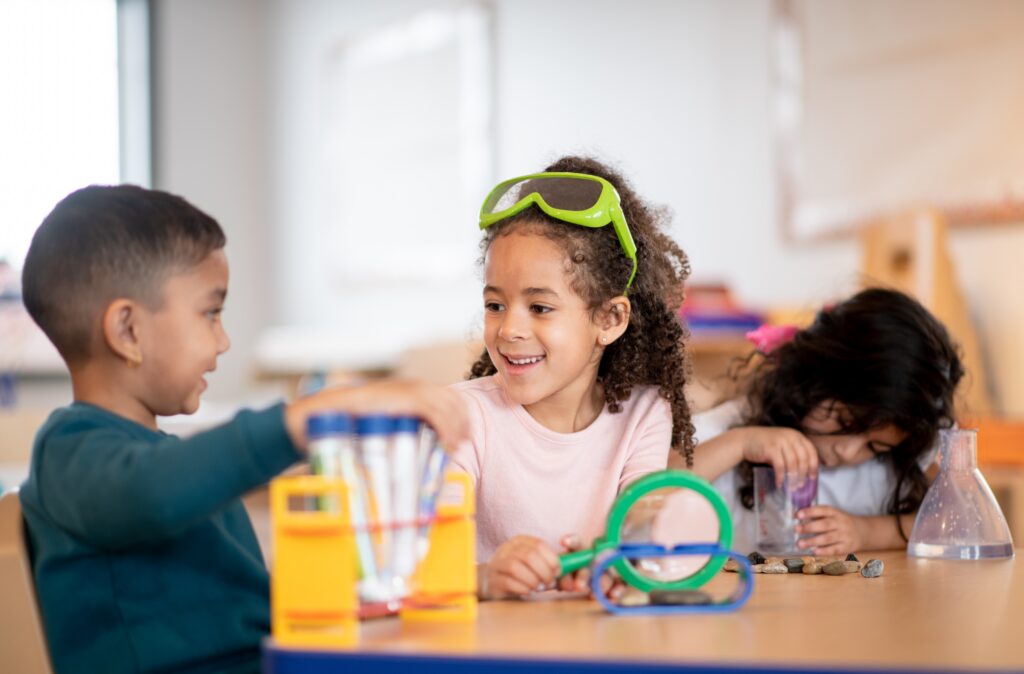 A diverse group of young children learn how to mix solutions together in class.